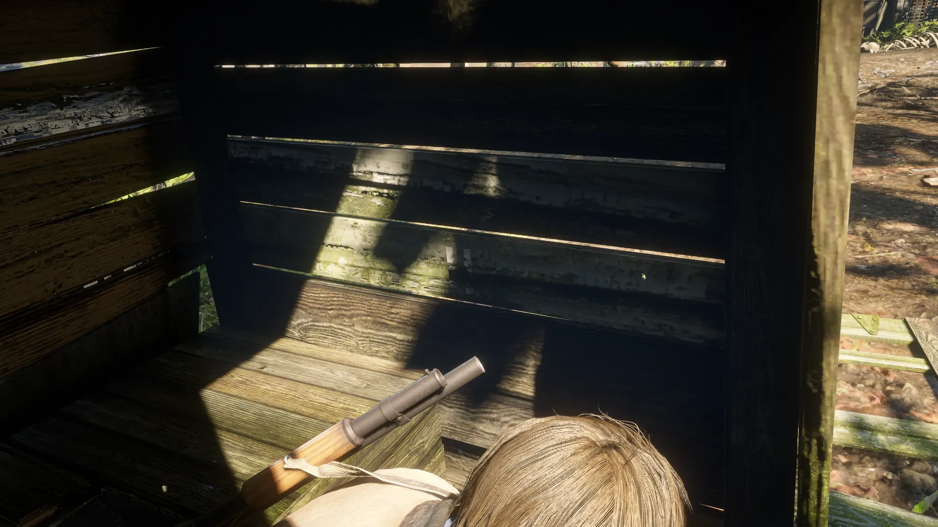 Arthur's over-the-shoulder view inside Outhouse 2, facing two white tally marks on a shadowed wooden wall.