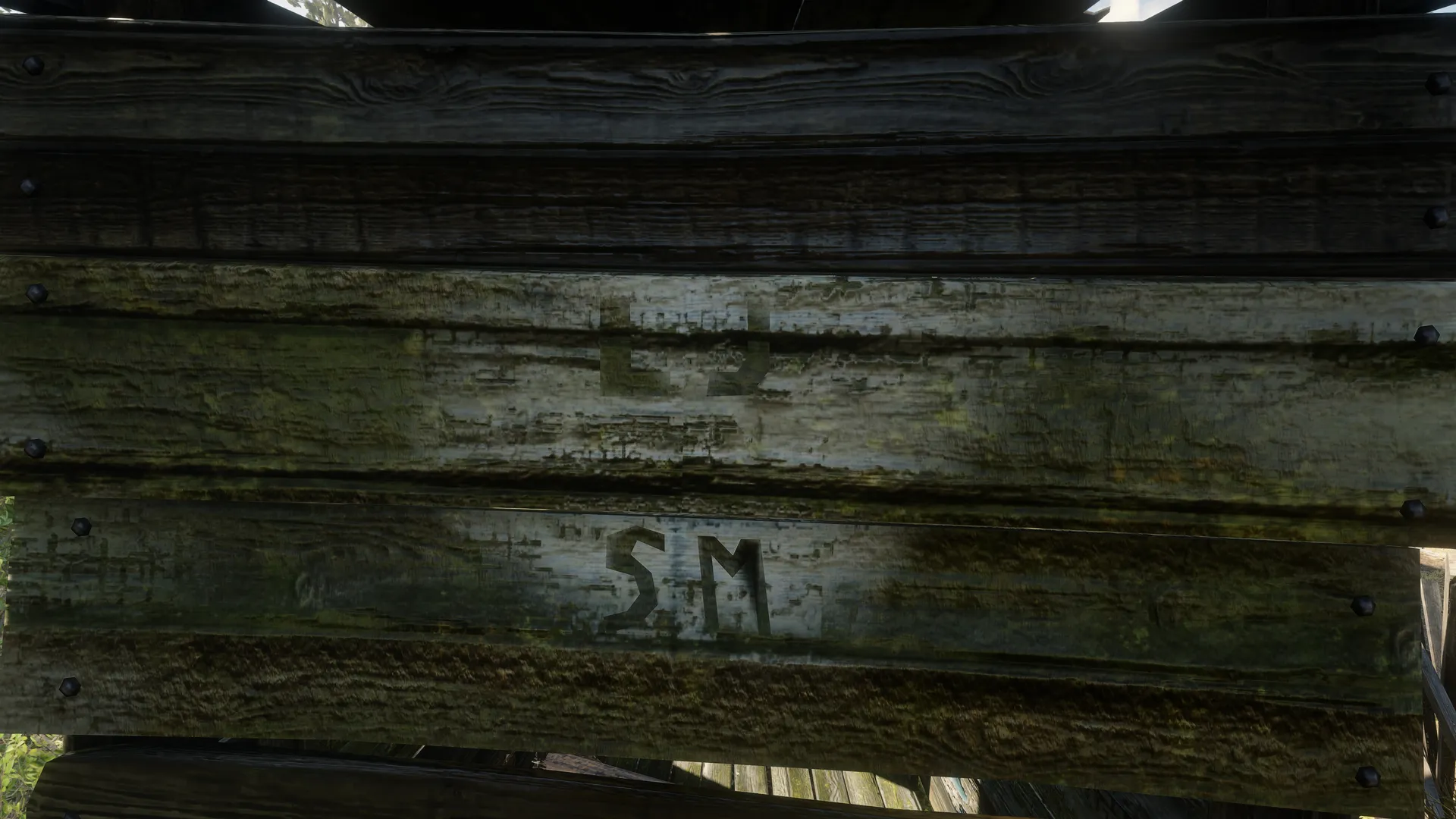 The letters LJ and SM painted across pale planks on the rear wall of Outhouse 4.